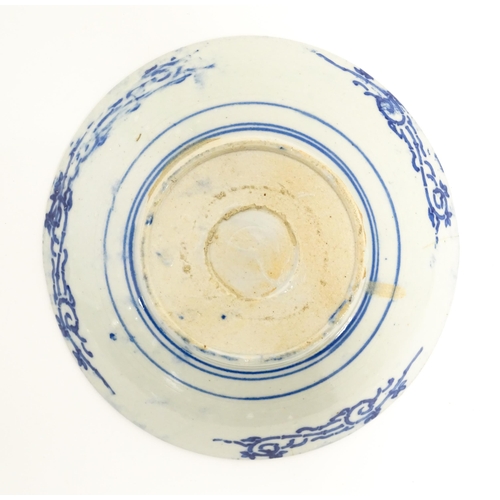 37 - A Japanese blue and white plate with central floral motif bordered by bands of patterned detail and ... 