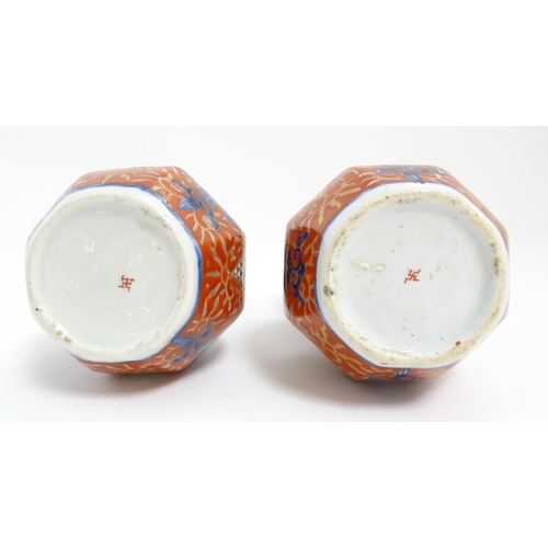 51 - A matched pair of Japanese double gourd vases decorated in the Imari palette with floral motifs and ... 