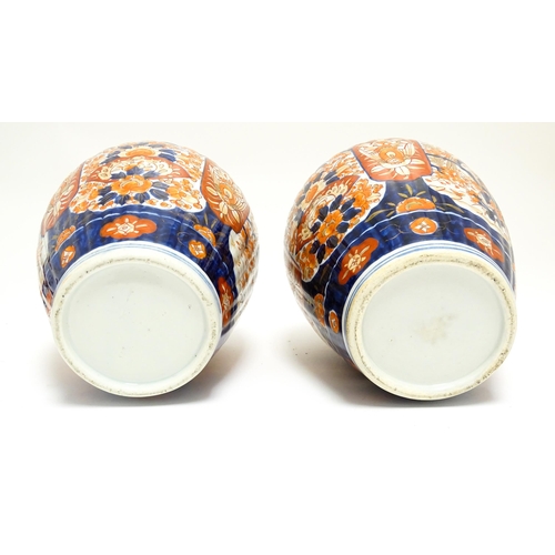 68 - A pair of Japanese lobed lidded vases decorated with birds, fans, flowers and foliage in the Imari p... 
