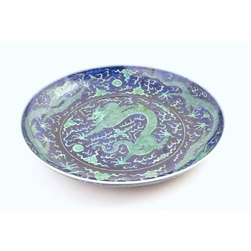 75 - A Chinese charger with a blue ground and green decoration depicting with dragons, flaming pearl and ... 