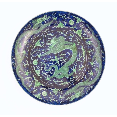 75 - A Chinese charger with a blue ground and green decoration depicting with dragons, flaming pearl and ... 