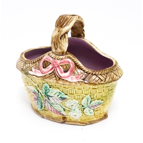 93 - A Victorian majolica basket with pink glazed interior, the woven style exterior with floral, foliate... 