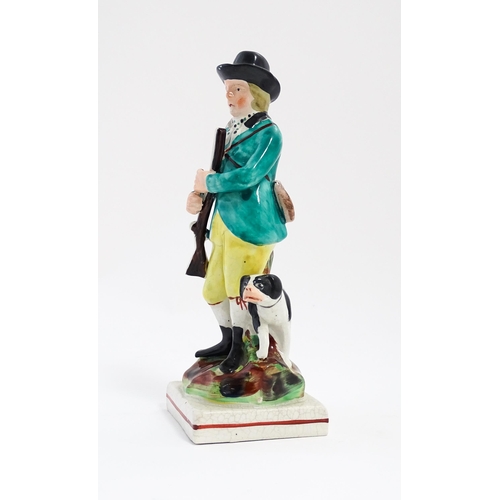 193 - A Staffordshire pearlware model of a huntsman and gun dog / hound on a squared base. Approx. 7 1/2