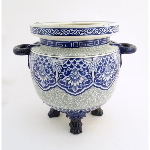 233 - A large Victorian Minton blue and white jardiniere / planter with twin handles standing on four feet... 