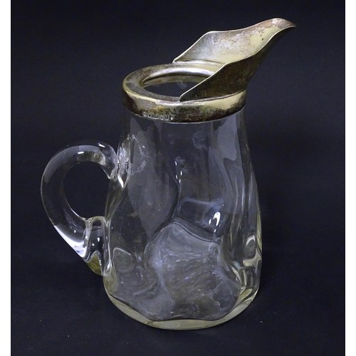 309 - A glass jug with loop handle and silver plate mounts. Approx 7 1/2