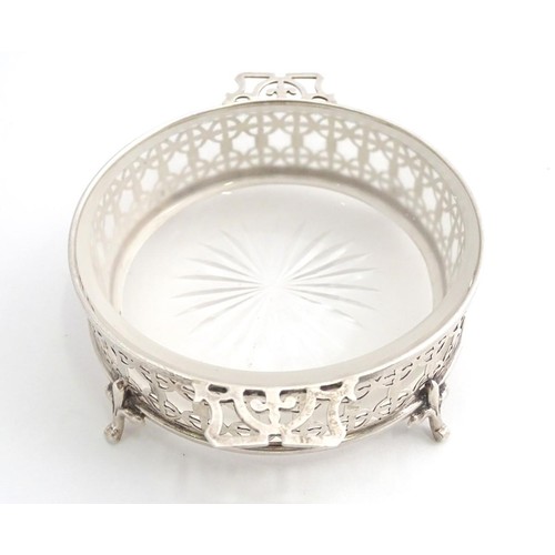 375 - A silver butter / preserve dish with twin handles and glass liner, The frame with geometric openwork... 