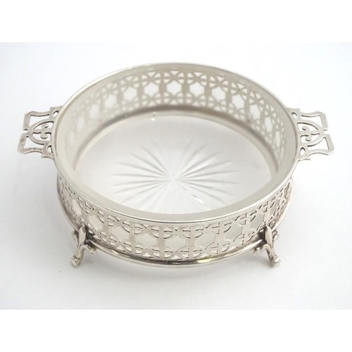 375 - A silver butter / preserve dish with twin handles and glass liner, The frame with geometric openwork... 