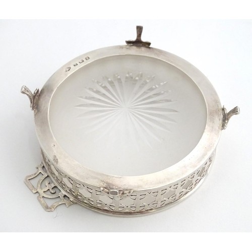 375 - A silver butter / preserve dish with twin handles and glass liner, The frame with geometric openwork... 