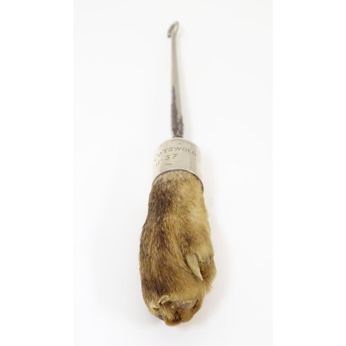 580 - Taxidermy : A button hook, the handle formed as an otter paw with silver collar engraved North Cotsw... 