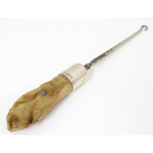 580 - Taxidermy : A button hook, the handle formed as an otter paw with silver collar engraved North Cotsw... 