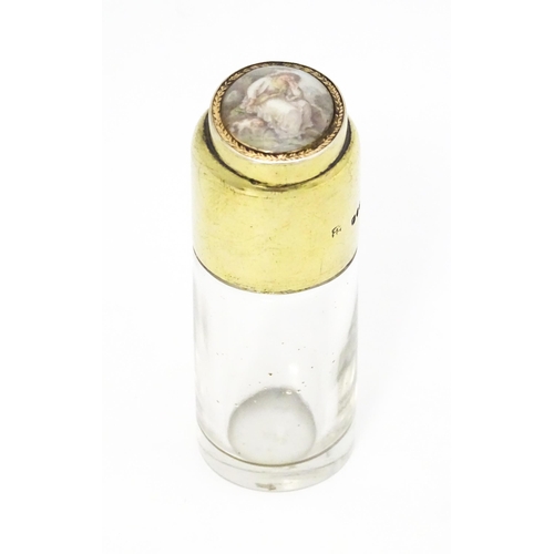 599 - A Victorian glass scent bottle with silver gilt top surmounted by a hand painted cabochon depicting ... 