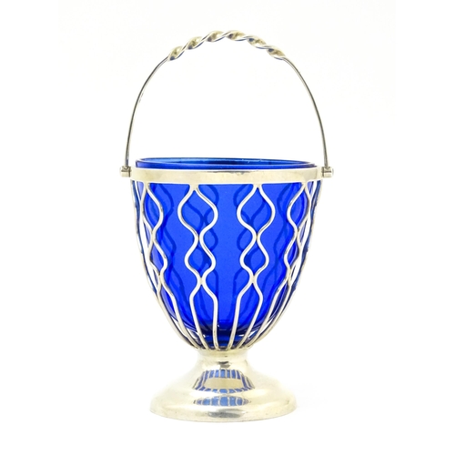 338 - A Victorian sugar basket with openwork decoration, swing handle and blue glass liner, hallmarked Bir... 