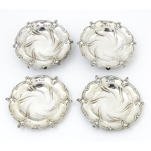 372 - Four silver dishes with embossed decoration, two raised on three out swept feet, hallmarked Birmingh... 