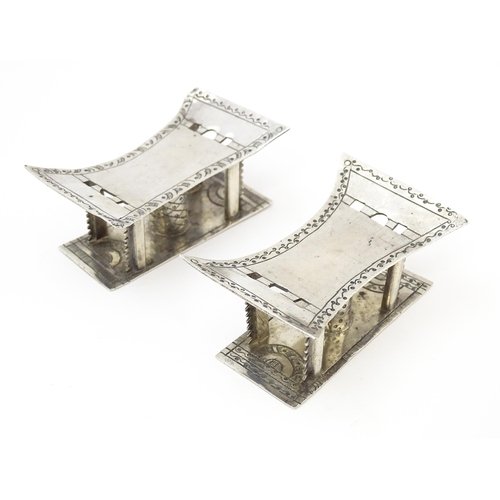 376 - A pair of white metal knife rests formed as African tribal Ashanti / Asante stools. Approx. 2 3/4