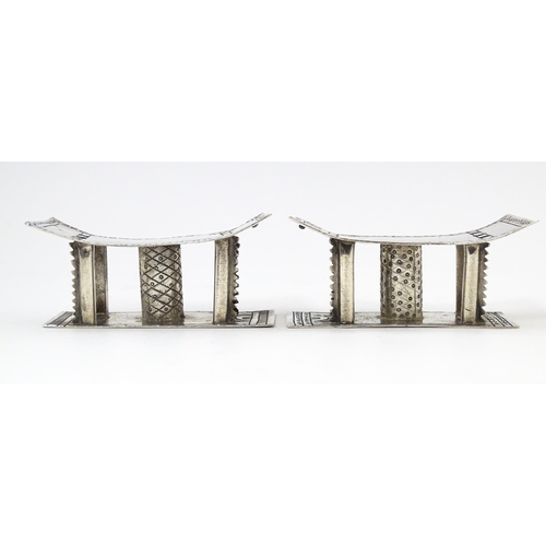 376 - A pair of white metal knife rests formed as African tribal Ashanti / Asante stools. Approx. 2 3/4