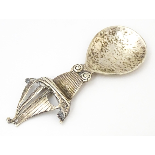 378 - An Arts & Crafts style silver caddy spoon with hammered bowl, the handle surmounted by a sailing boa... 