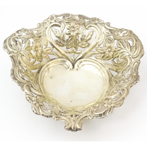 381 - A silver bon bon dish / sweetmeat basket of stylised heart form with pierced, floral and acanthus sc... 