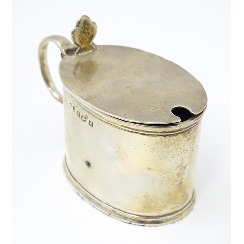 389 - A silver mustard pot of oval form with blue glass liner, hallmarked Birmingham 1914, maker George Un... 