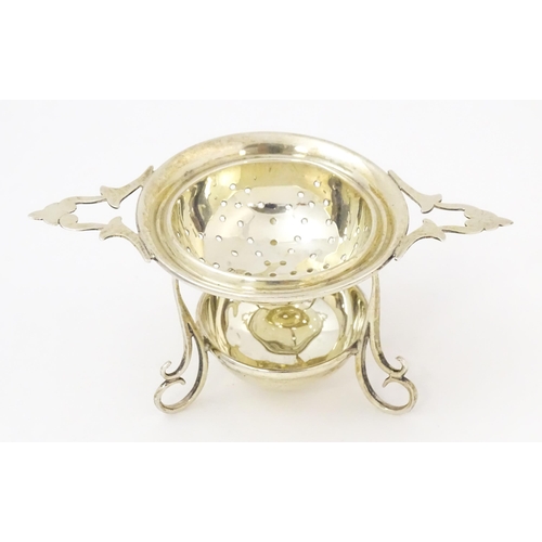 396 - A silver twin handled strainer on stand hallmarked Birmingham 1933, maker Sanders & Mackenzie. Appro... 