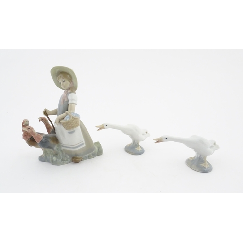 127 - Three Lladro models comprising Little Girl with Turkeys no. 1180, and two models of geese. Largest a... 