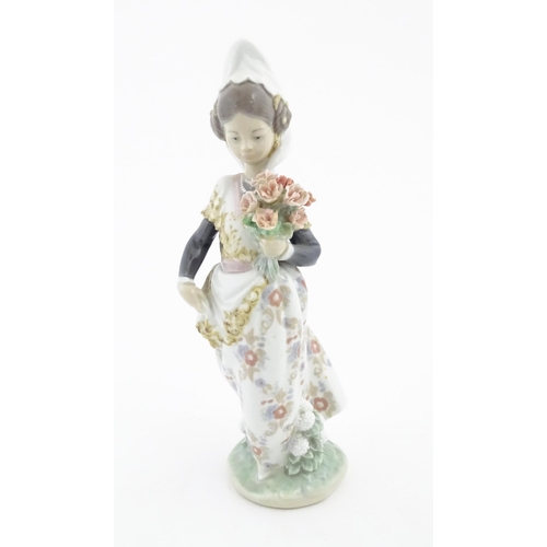 128 - A Lladro figure Valencian Girl with Flowers no. 1304. Approx. 9 1/2