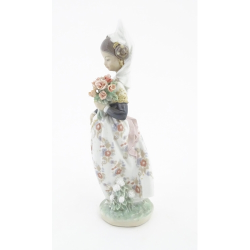 128 - A Lladro figure Valencian Girl with Flowers no. 1304. Approx. 9 1/2