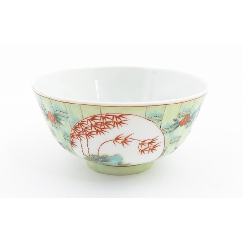 13 - A Chinese famille verte bowl decorated with stylised bamboo and flowers. Character marks under. Appr... 