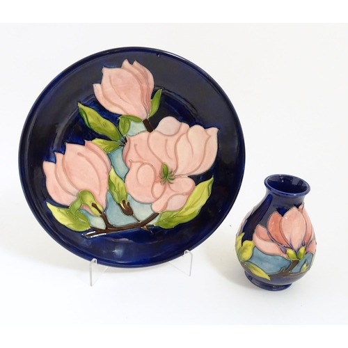 167 - A Moorcroft plate and small vase both decorated in the Magnolia pattern. Marked under. Vase approx. ... 