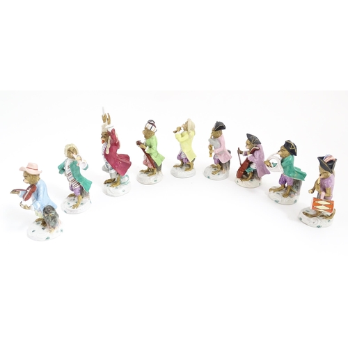 184 - Nine Continental porcelain monkey band 
/ orchestra figures modelled as monkey musicians with variou... 