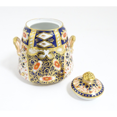 223 - A Derby tea bowl and saucer with gilt detail. Marked under. Together with a twin handled lidded suga... 