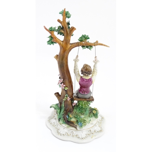 228 - A Capodimonte model of a young boy on a swing. Approx. 10 1/2