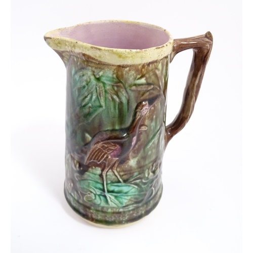 245 - A majolica jug with relief bird and foliate detail. Approx. 7 1/2