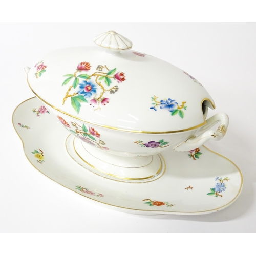 255 - A soup tureen and stand with floral and foliate decoration with gilt highlights. Together with two m... 