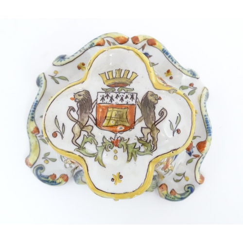 259 - A French faience inkwell of shaped form with armorial to top and scrolling foliate detail. Marked un... 