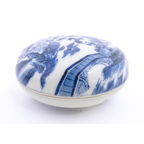 29 - A Chinese blue and white ink box of circular form decorated with figures in a landscape scene with a... 