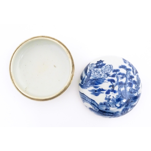 29 - A Chinese blue and white ink box of circular form decorated with figures in a landscape scene with a... 