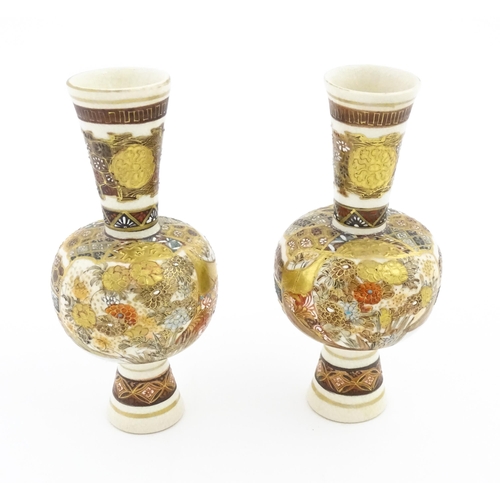 33 - A pair of small Japanese satsuma vases with elongated necks decorated with figures and banded detail... 