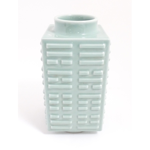 5 - A Chinese celadon vase of squared form with relief detail. Character marks under. Approx. 11