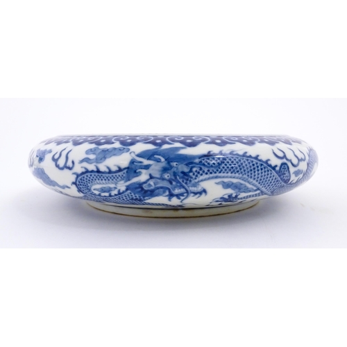 54 - A Chinese blue and white dish decorated with dragons amidst clouds. Character marks under. Approx. 1... 