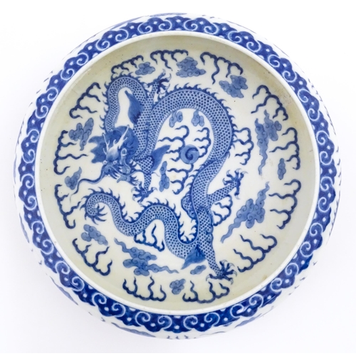 54 - A Chinese blue and white dish decorated with dragons amidst clouds. Character marks under. Approx. 1... 