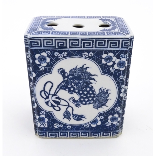 55 - A Chinese blue and white flower brick decorated with foo dogs within vignettes bordered by prunus fl... 