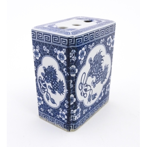 55 - A Chinese blue and white flower brick decorated with foo dogs within vignettes bordered by prunus fl... 