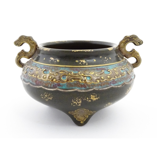 57 - A small Chinese censer with twin handles with banded decoration in relief depicting stylised dragons... 