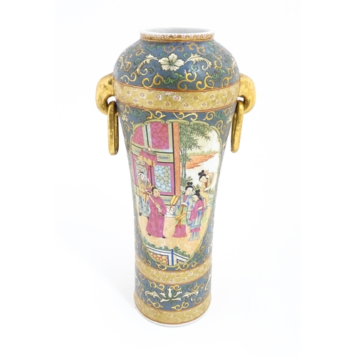 60 - A Chinese vase with twin elephant mask and ring handles decorated with figures with fans on a garden... 