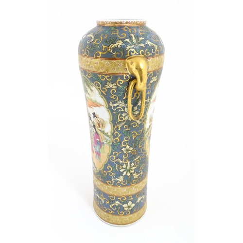 60 - A Chinese vase with twin elephant mask and ring handles decorated with figures with fans on a garden... 