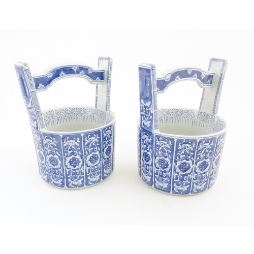 62 - A pair of Chinese blue and white planters formed as water pails / buckets with floral and foliate de... 