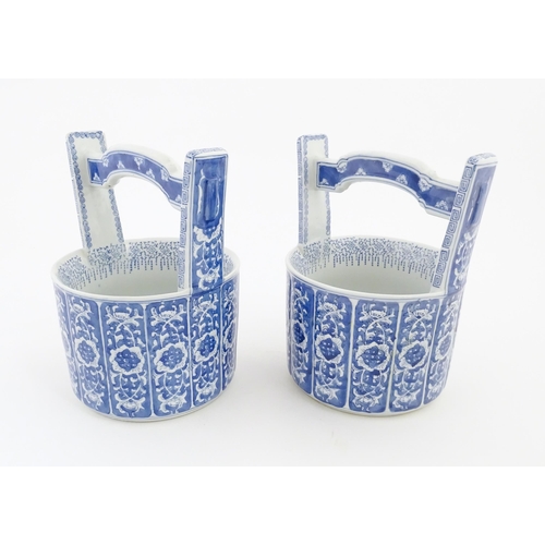 62 - A pair of Chinese blue and white planters formed as water pails / buckets with floral and foliate de... 