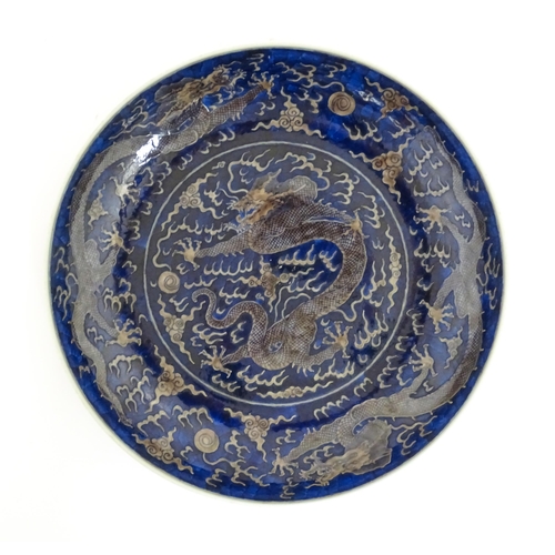 64 - A Chinese charger with blue ground decorated with dragons, flaming pearls and stylised clouds. Chara... 