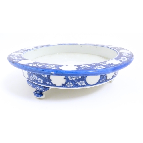 70 - A Chinese blue and white stand of circular form raised on three feet decorated with prunus flowers. ... 
