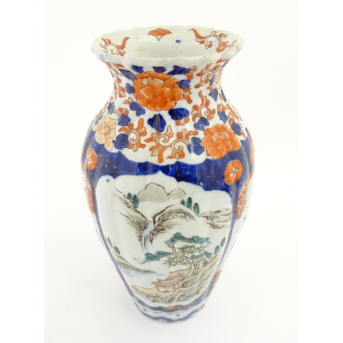 72A - A Japanese vase of lobed form in the Imari palette decorated with flowers and foliage, and landscape... 